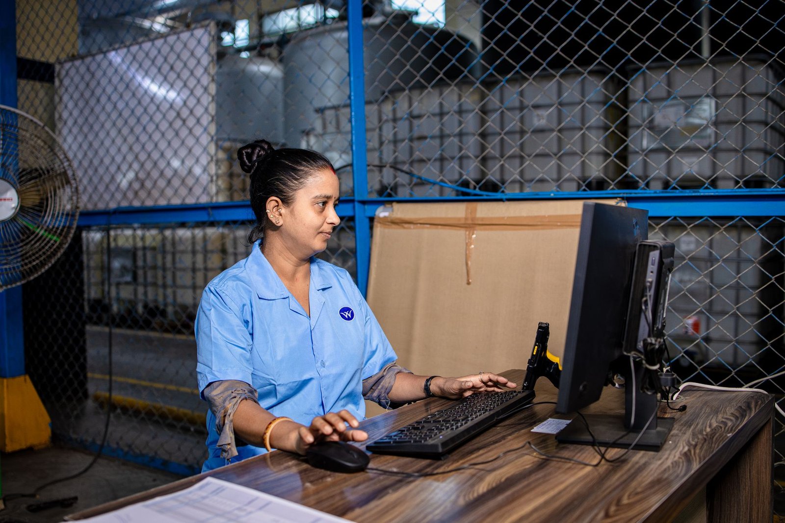Qué es un ERP: trabajadora gestionando el stock en el ordenador de un almacén
